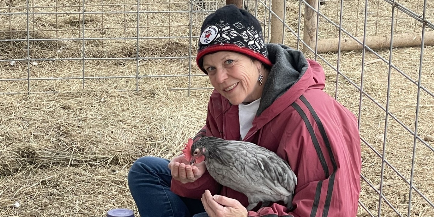 Dr. Laura holding a chicken on the farm